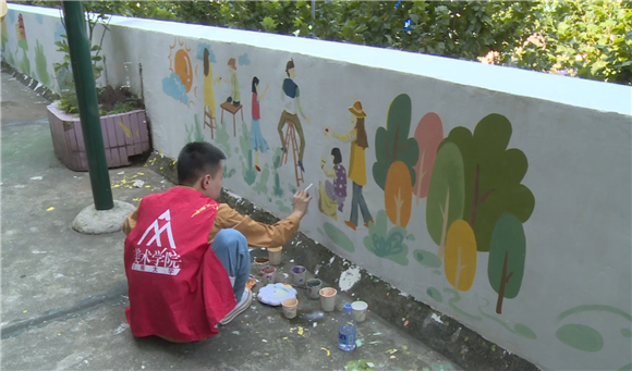 志愿者正在对墙面进行涂绘。通讯员 向金城 摄