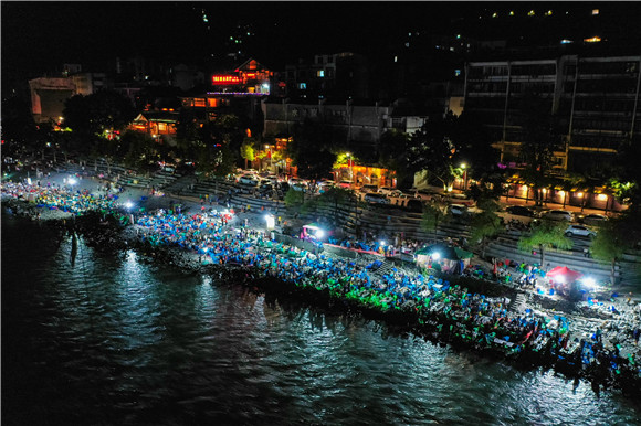夜幕下大宁古城成千上万的游客坐在大宁河边品尝巫溪烤鱼。巫溪县文化旅游委供图 华龙网发