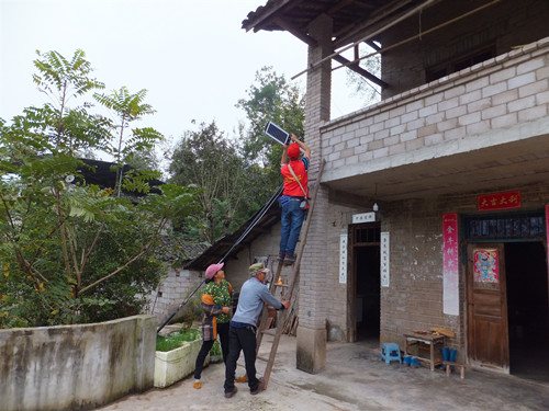 村组干部、志愿者为村民安装太阳能庭院灯。通讯员 隆伟 摄
