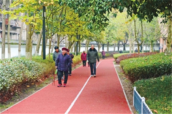梁山城区报国公园，市民在新铺设的塑胶跑道上散步。通讯员 张晓庆 摄