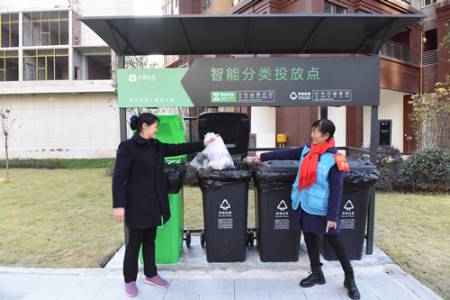 志愿者在指导市民投放垃圾。特约通讯员  隆太良  摄