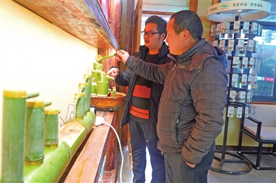 竹山镇猎神村农村电商服务点，李安涛（左）在给游客推介竹工艺品。通讯员 谢清城 摄