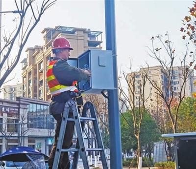 梁平城区智能停车项目红桂路段施工现场，工人在安装设备。通讯员 郎兴花
