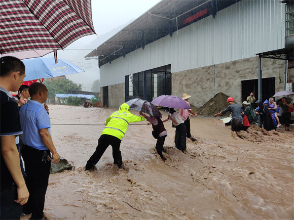 云阳民警在暴雨中帮助受困群众转移。云阳县公安局供图 华龙网发