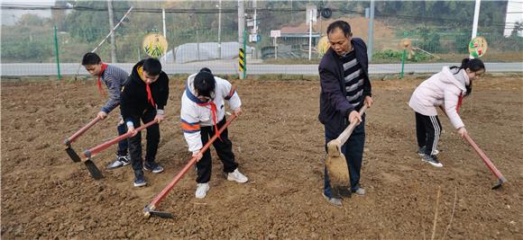 农技人员给学生做劳动示范。通讯员 赵武强 摄