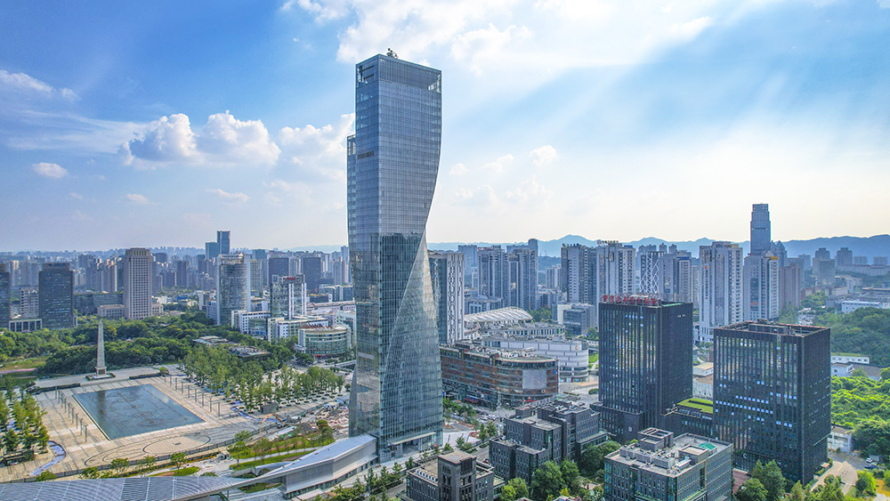 2021年8月9日，两江幸福广场上，一高楼凭借独特的外观、扭曲的结构，在众多楼宇项目中脱颖而出，扭成了“小蛮腰”。