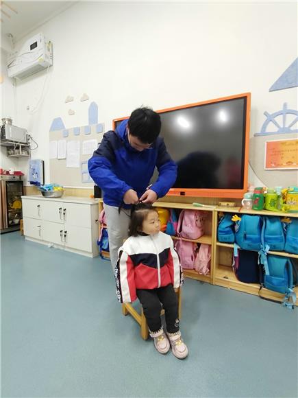 2李雪峰为小女孩梳头。特约通讯员 李慧敏 摄