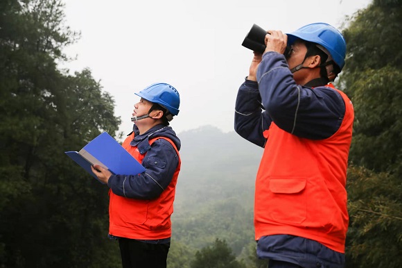 12月29日，电力员工在毓青山脉南段燃灯山巡视检查10千伏大梅线。通讯员 蒋佩 摄