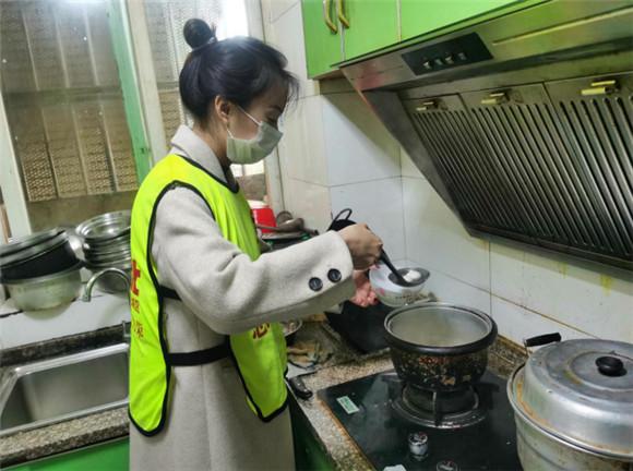 志愿者在低保户老人家中为老人煮汤圆。王家街道办事处供图 华龙网发