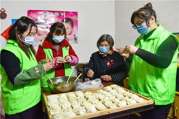 志愿者和刘淑容老人（右二）一起包饺子。特约通讯员 唐洪琼 摄