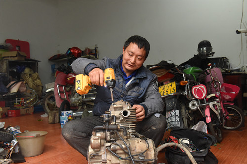 田富在维修摩托车。特约通讯员 隆太良 摄