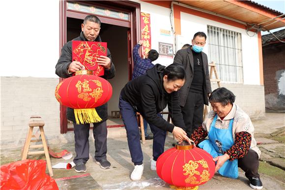 复生桥村脱贫户盘昌彪夫妇与帮扶干部一起挂灯笼贴春联。特约通讯员 陈仕川 摄