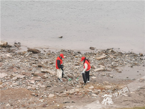 志愿者在江岸捡拾垃圾。华龙网—新重庆客户端记者  舒婷 摄