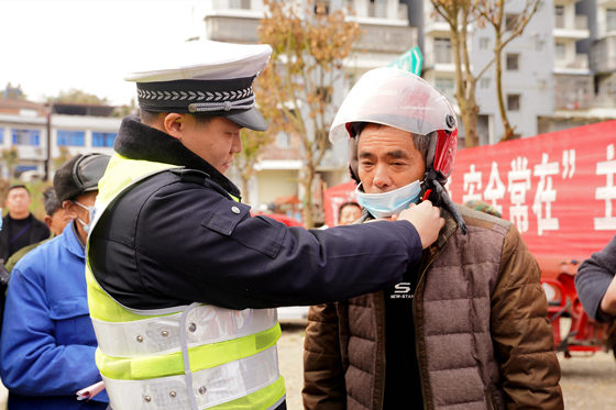 交巡警为群众示范如何正确佩戴安全头盔。通讯员 周可东 摄