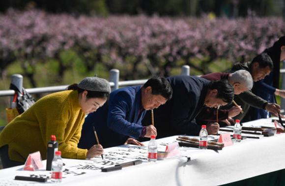 3月22日，参加“清廉笔会”主题活动的书法爱好者在奉化区萧王庙街道林家桃园内创作。新华社记者-黄宗治-摄