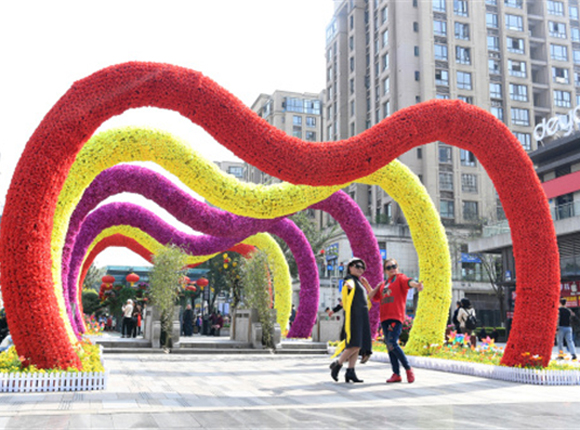 3月24日，市民在重庆市巴南区龙洲湾商街赏花观光。新华社记者 唐奕 摄