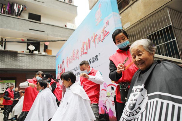 永川区“周末红”志愿者在胜利路街道大巷子为市民免费理发。陈仕川 摄