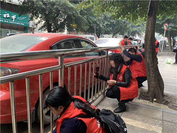 3志愿者清洁道路护栏。华龙网—新重庆客户端记者 陶彦燕 摄