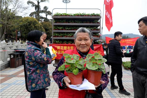 鲜花赠市民，文明伴我行。特约通讯员 谭显全 摄