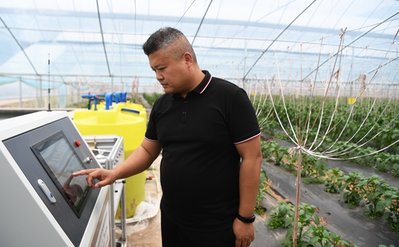 安坪镇下坝社区大棚蔬菜基地工作人员在操作水肥一体化管理设备。