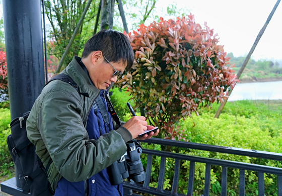 在重庆梁平双桂湖国家湿地公园，杨秀勇正在写观鸟记录。通讯员  石楚园  摄