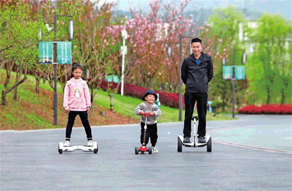 6双桂湖国家湿地公园，家长带着孩子开心地滑着滑板车。通讯员 向成国 摄