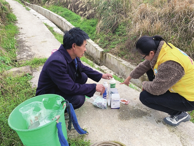 志愿者在指导农户科学施用农药。通讯员 熊晓敏 摄