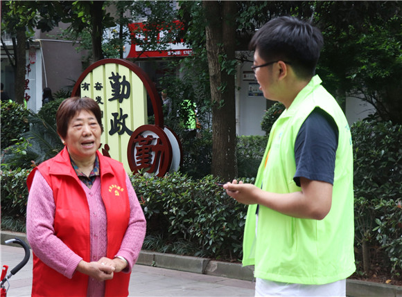 6记者采访社区志愿者。华龙网-新重庆客户端 葛彧 摄