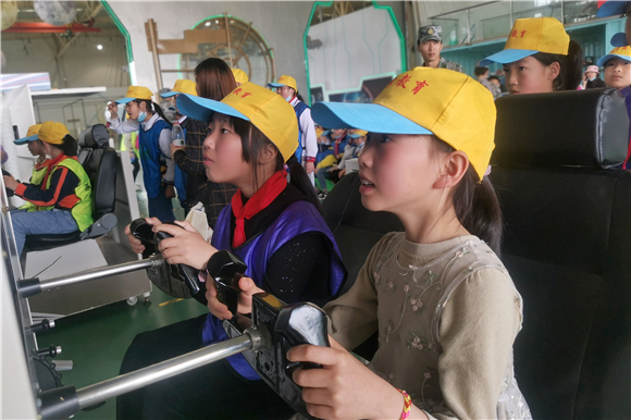 在重庆飞行家航空科普基地，虎城镇中心小学学生体验飞机模拟飞行。通讯员 彭琼 摄