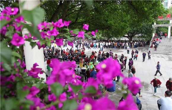 铜梁城区，市民在鲜花掩映的广场上休息。（通讯员 陈刚 摄）
