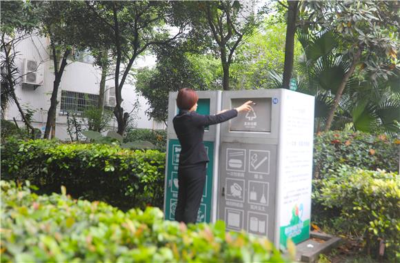 市民在小区设置的智能垃圾分类投放箱旁投放垃圾。通讯员 陈刚 摄