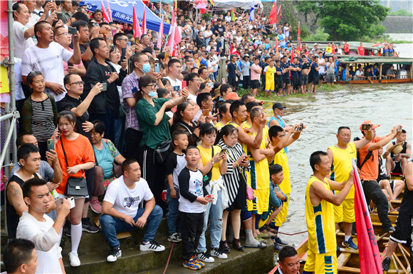 河岸两旁的群众为参赛选手们加油助威。活动主办方供图