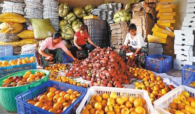 柏家镇三新村三新桃缘基地，村民在对黄桃进行筛选、装箱。