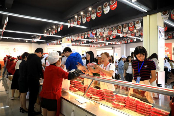 重庆百人旅游团在重庆真本味食品有限公司展示区购买张鸭子系列产品。熊伟 摄