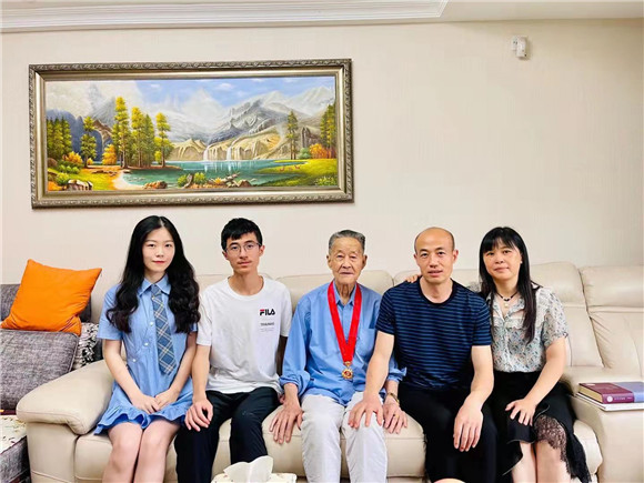 刘德正戴着“光荣在党50年”纪念章与家人合影。通讯员 黄博智 摄