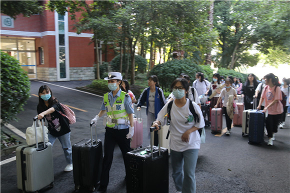 王玉双帮学生搬运行李行走在人群中。云阳县公安局供图 华龙网发