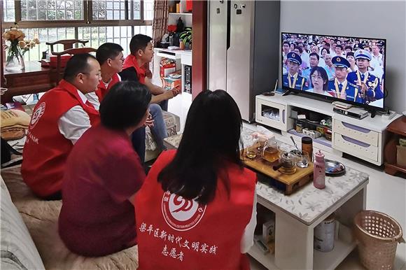 梁平区新时代文明实践志愿者们正在陪王心琼老人观看庆祝中国共产党成立100周年大会直播。通讯员 胡旭 摄