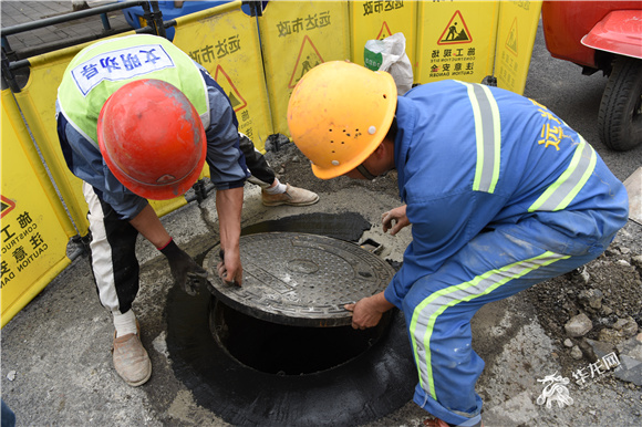 工作人员正在维护井盖。 华龙网-新重庆客户端记者 李成 摄