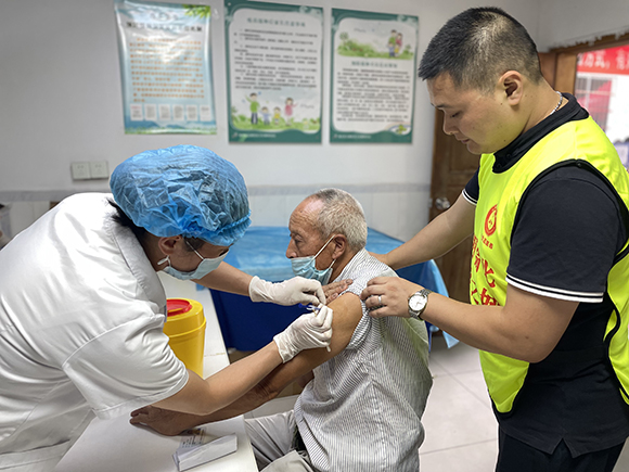 志愿者陪护老人接种新冠疫苗。王家街道办事处供图 华龙网发
