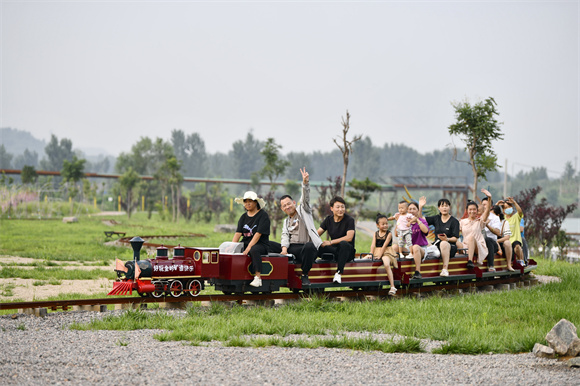 游客在金岭矿山传奇景区内乘坐迷你火车游玩。