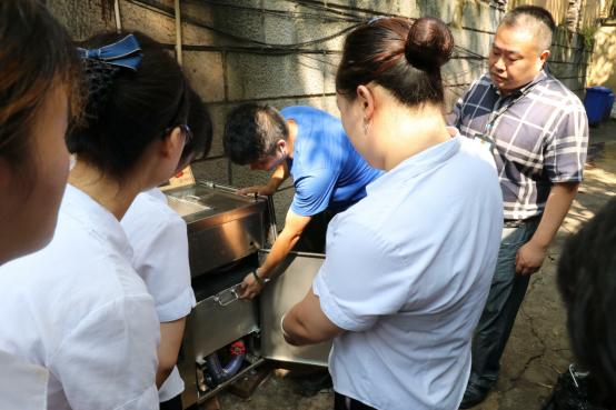 2工作人员操作使用厨余垃圾智能分类设备。通讯员 吴远明 摄