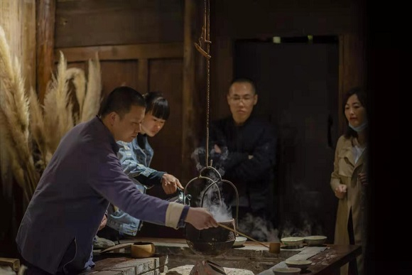 1刘晓兵（左一）烹茶待客，向爱茶者讲解石柱老鹰茶的历史。中域农业公司供图 华龙网发