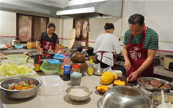罗贤斌（右一）正在厨房里忙活着准备客人的午餐。通讯员 胡来 摄