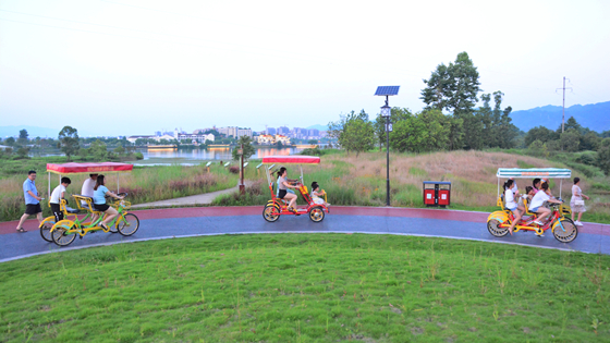 重庆梁平双桂湖国家湿地公园梁山草甸二期，市民正在环湖自行车道游玩。特约通讯员 张常伟 摄