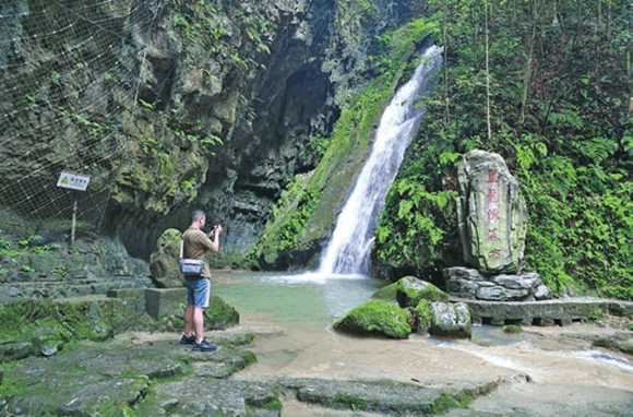 游客在黑龙潭瀑布景点拍照、游玩。通讯员 熊伟 摄