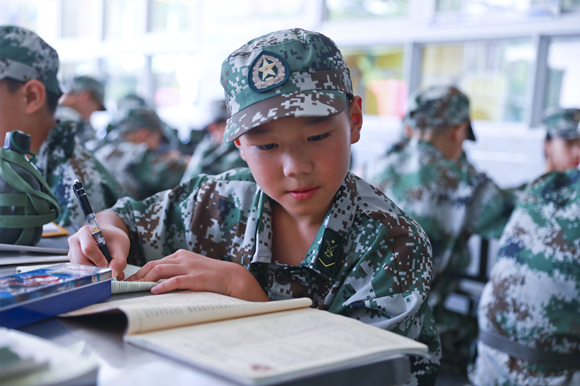 7月25日，第二届少年军校成长营活动中，参训学员在认真做作业。熊伟 摄