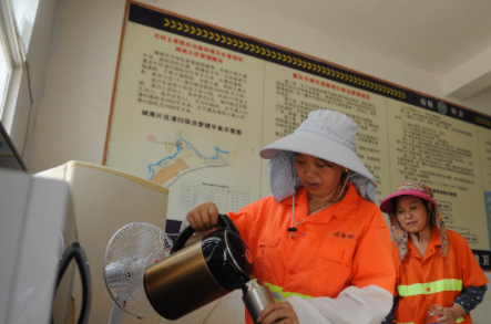 2环卫工人在“劳动者港湾”倒水喝。通讯员 龙泓 摄