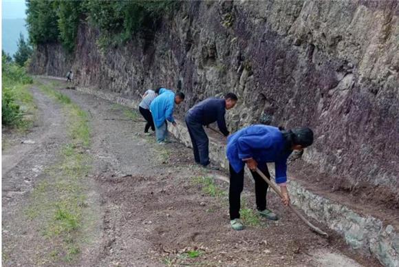 紫安村组织志愿者整修泥结石道路。通讯员 向爱平 摄
