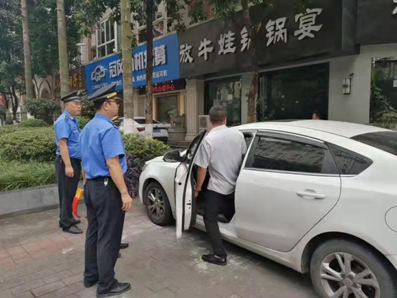 执法人员对违法停放车辆进行劝导。  九龙坡区城市管理局