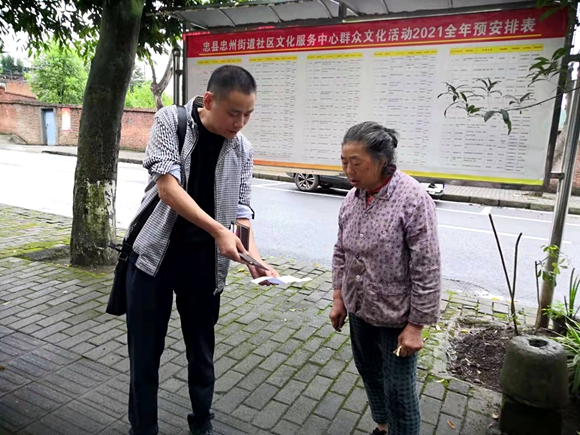 志愿者在顺溪社区乡居民介绍新冠疫苗。忠县县委宣传部供图
